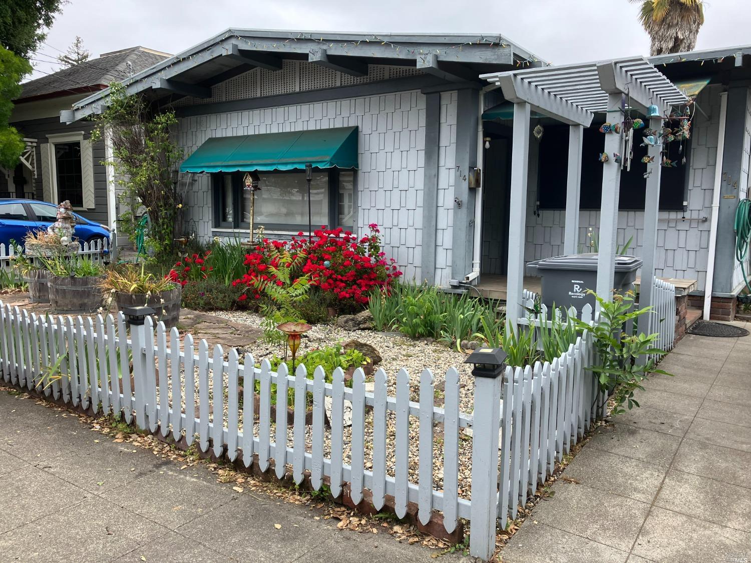 a front view of house and yard with wooden fence