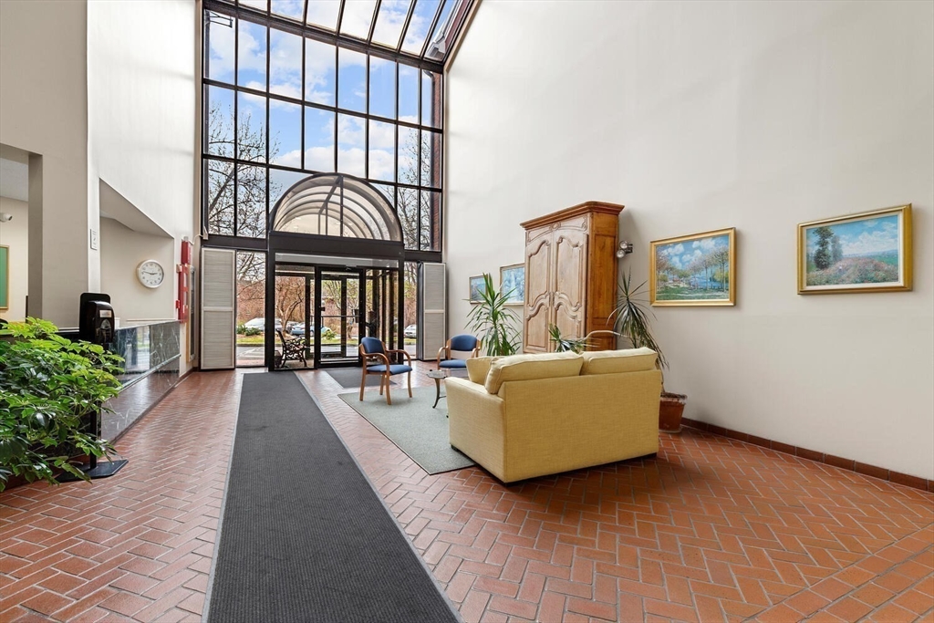 100 Rosemary Way, Unit 325 Needham, MA 02494 - Photo 22 of 24 a living room with furniture fireplace and lots of windows
