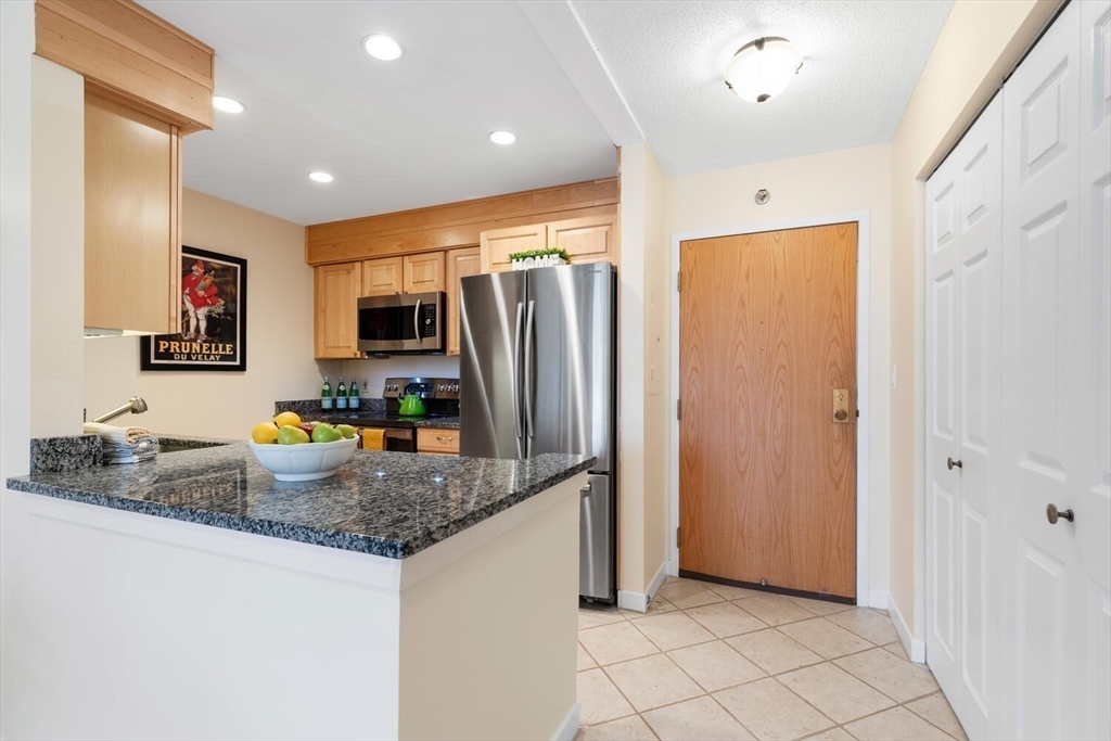 100 Rosemary Way, Unit 325 Needham, MA 02494 - Photo 6 of 24 a kitchen with stainless steel appliances granite countertop a refrigerator and a sink