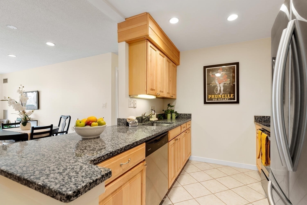 100 Rosemary Way, Unit 325 Needham, MA 02494 - Photo 7 of 24 a kitchen with stainless steel appliances granite countertop a sink stove and cabinets