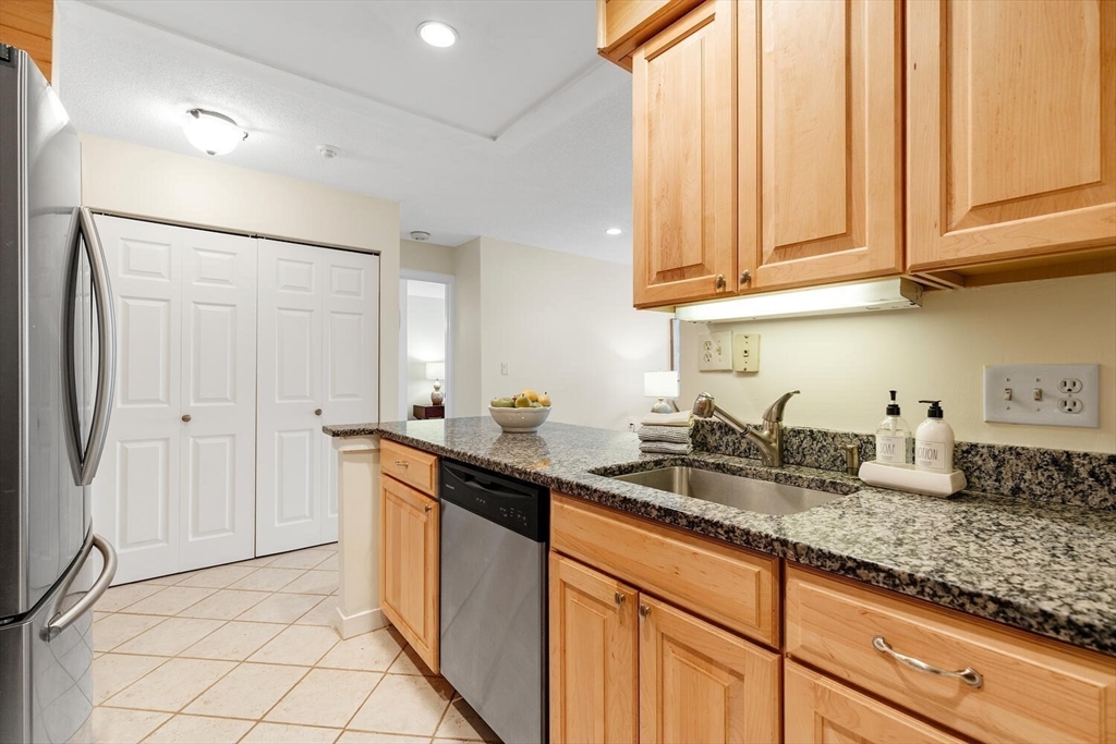 100 Rosemary Way, Unit 325 Needham, MA 02494 - Photo 9 of 24 a kitchen with granite countertop a sink and a white cabinets