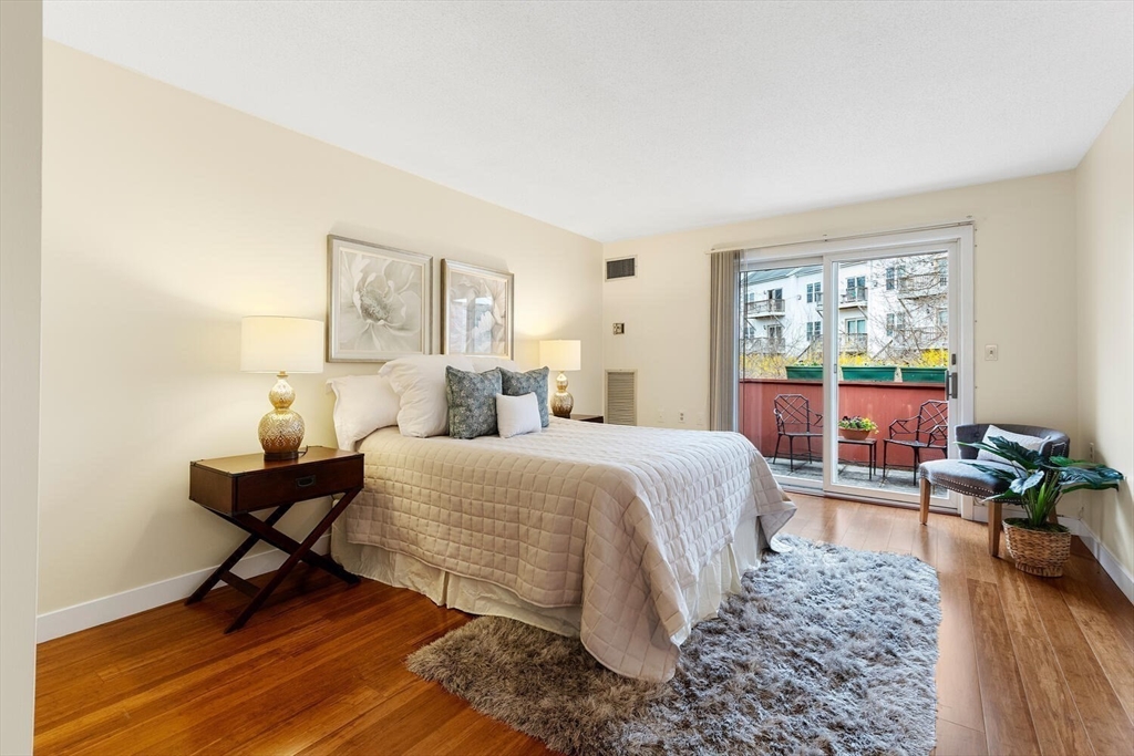 100 Rosemary Way, Unit 325 Needham, MA 02494 - Photo 10 of 24 a bedroom with a bed and wooden floor