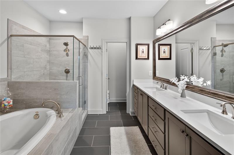 1956 Skyfall Circle Atlanta, GA 30319 - Photo 18 of 49 a bathroom with a granite countertop double vanity sink a mirror a bathtub and shower