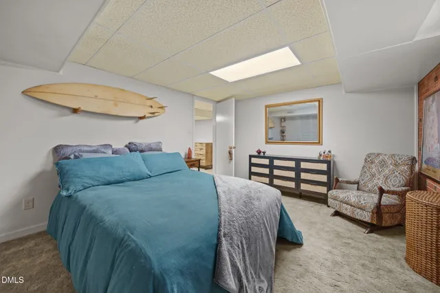 a spacious bedroom with a bed and wooden floor