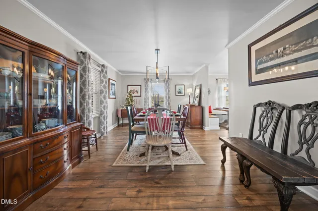 a kitchen with stainless steel appliances kitchen island granite countertop a table chairs sink and cabinets