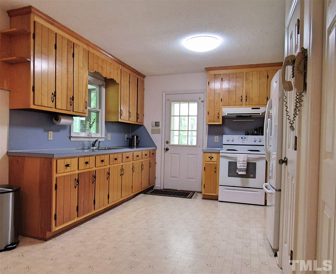 7204 Jock Road Bahama, NC 27503 - Photo 8 of 25 a kitchen with stainless steel appliances granite countertop a stove a sink and a refrigerator