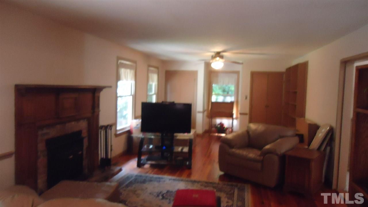 5409 Old Forge Circle Raleigh, NC 27609 - Photo 9 of 19 a living room with furniture a fireplace and a flat screen tv