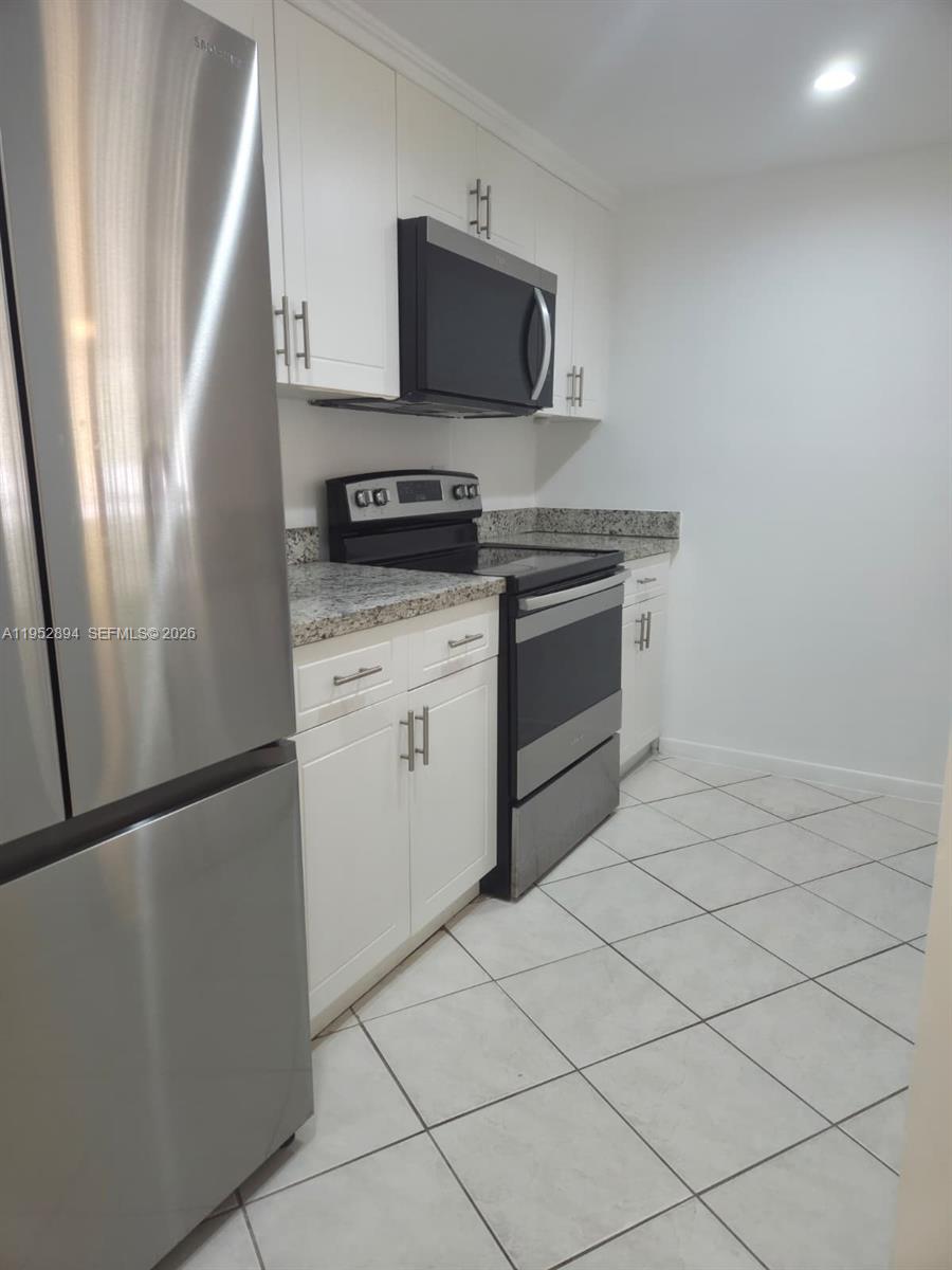 7075 Northwest 186th Street, Unit C104 Hialeah, FL 33015 - Photo 1 of 24 a kitchen with stainless steel appliances a refrigerator sink and microwave