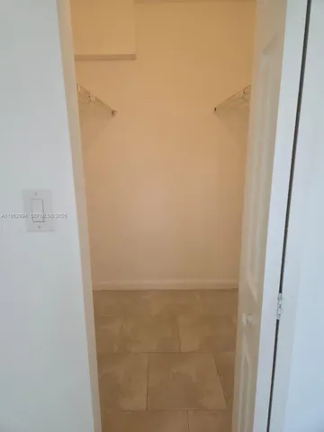 a view of an empty room with closet and chandelier fan