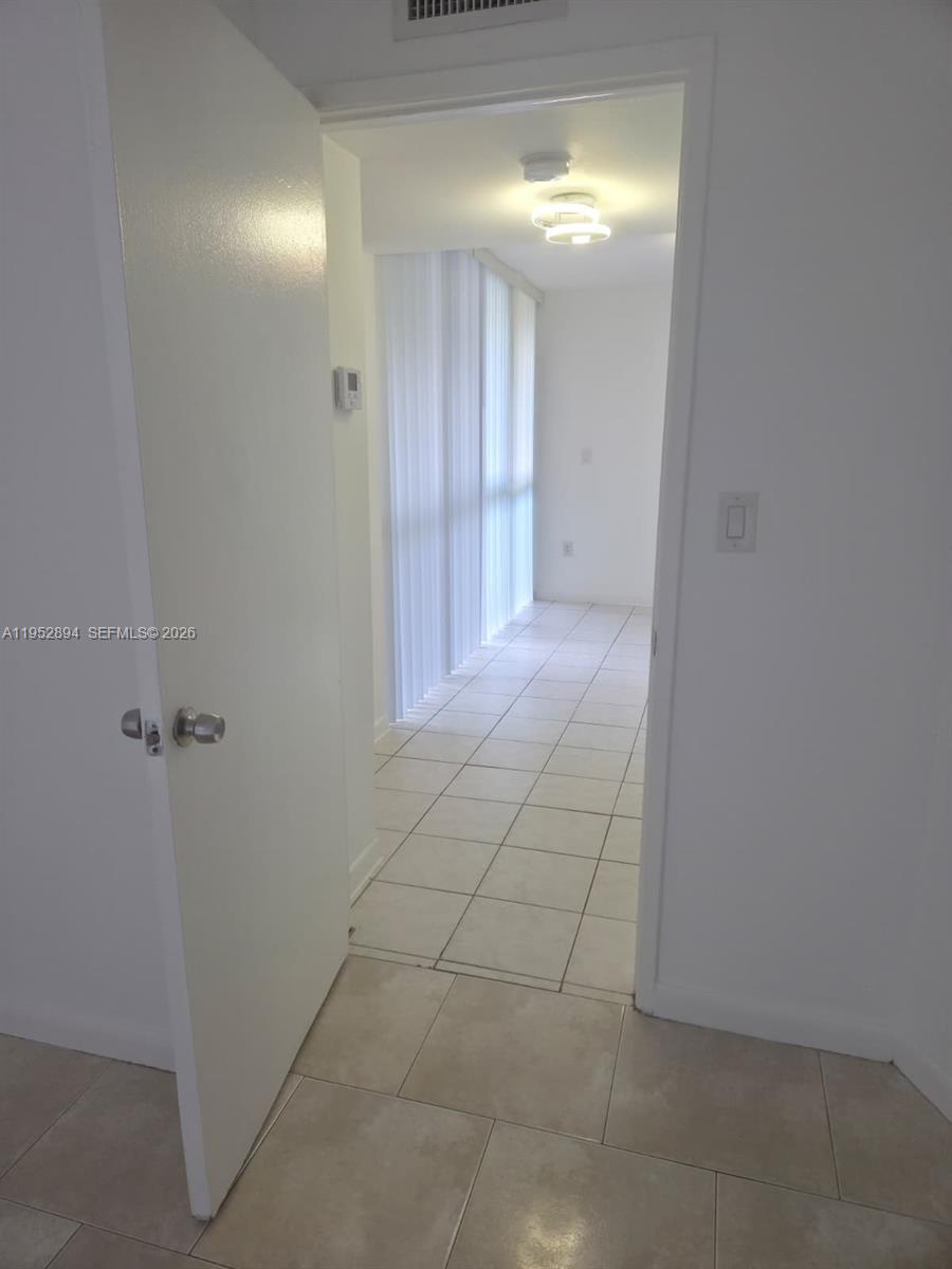 7075 Northwest 186th Street, Unit C104 Hialeah, FL 33015 - Photo 18 of 24 a view of an empty room with closet and chandelier fan