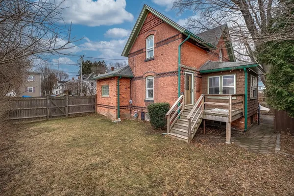 a backyard of a house with barbeque oven and wooden fence