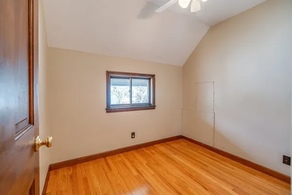 a view of an empty room with window and wooden floor