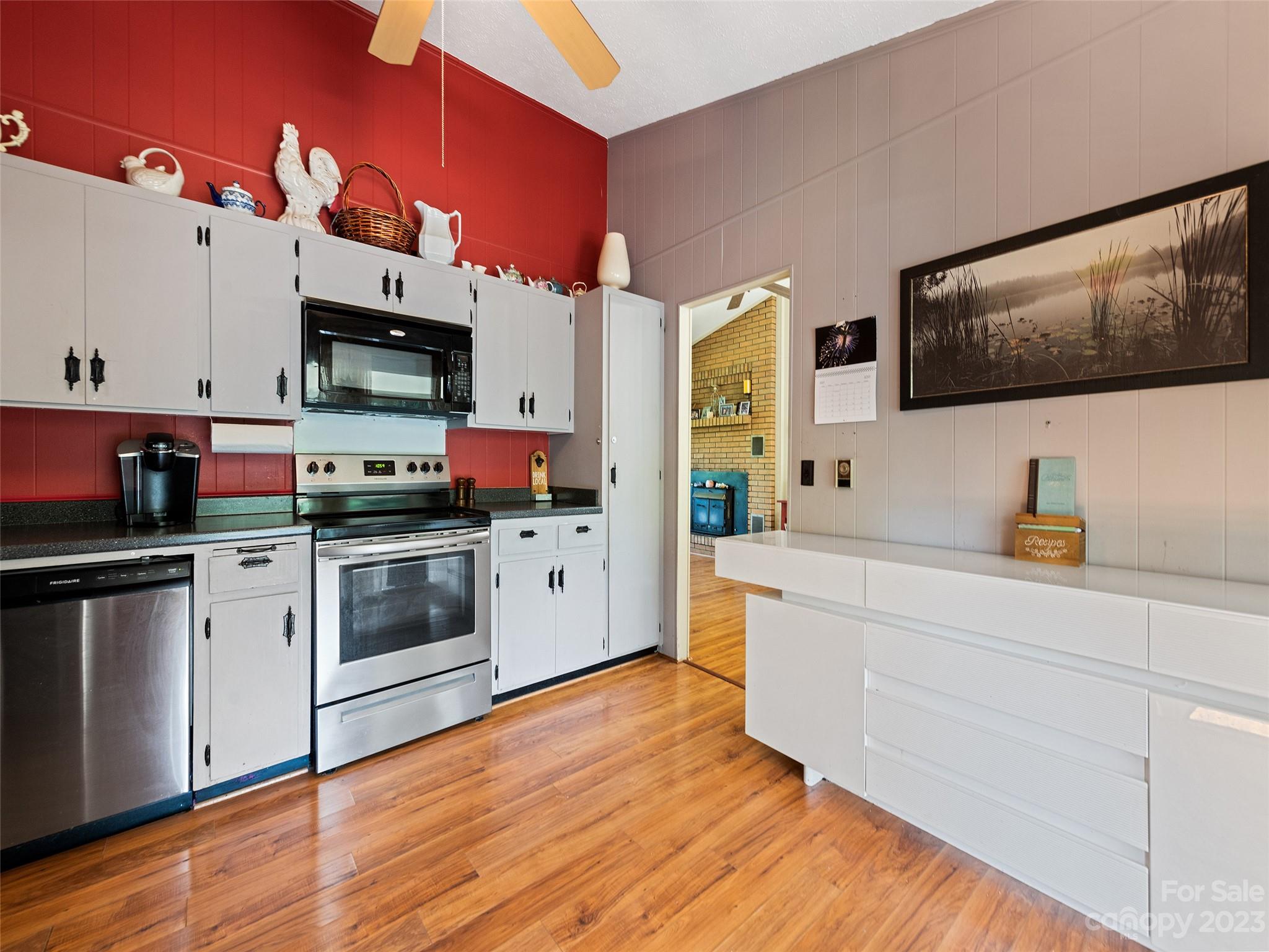69 Patton Cemetery Road Swannanoa, NC 28778 - Photo 16 of 35 a kitchen with stainless steel appliances a white stove top oven a sink dishwasher and white cabinets with wooden floor