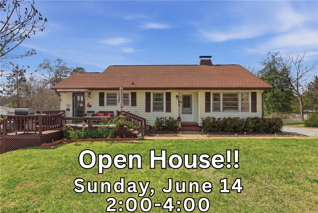 602 South Tugaloo Street Walhalla, SC 29691 - Photo 1 of 39 A classic ranch-style home features a spacious wooden deck for outdoor enjoyment, set against a backdrop of mature trees.