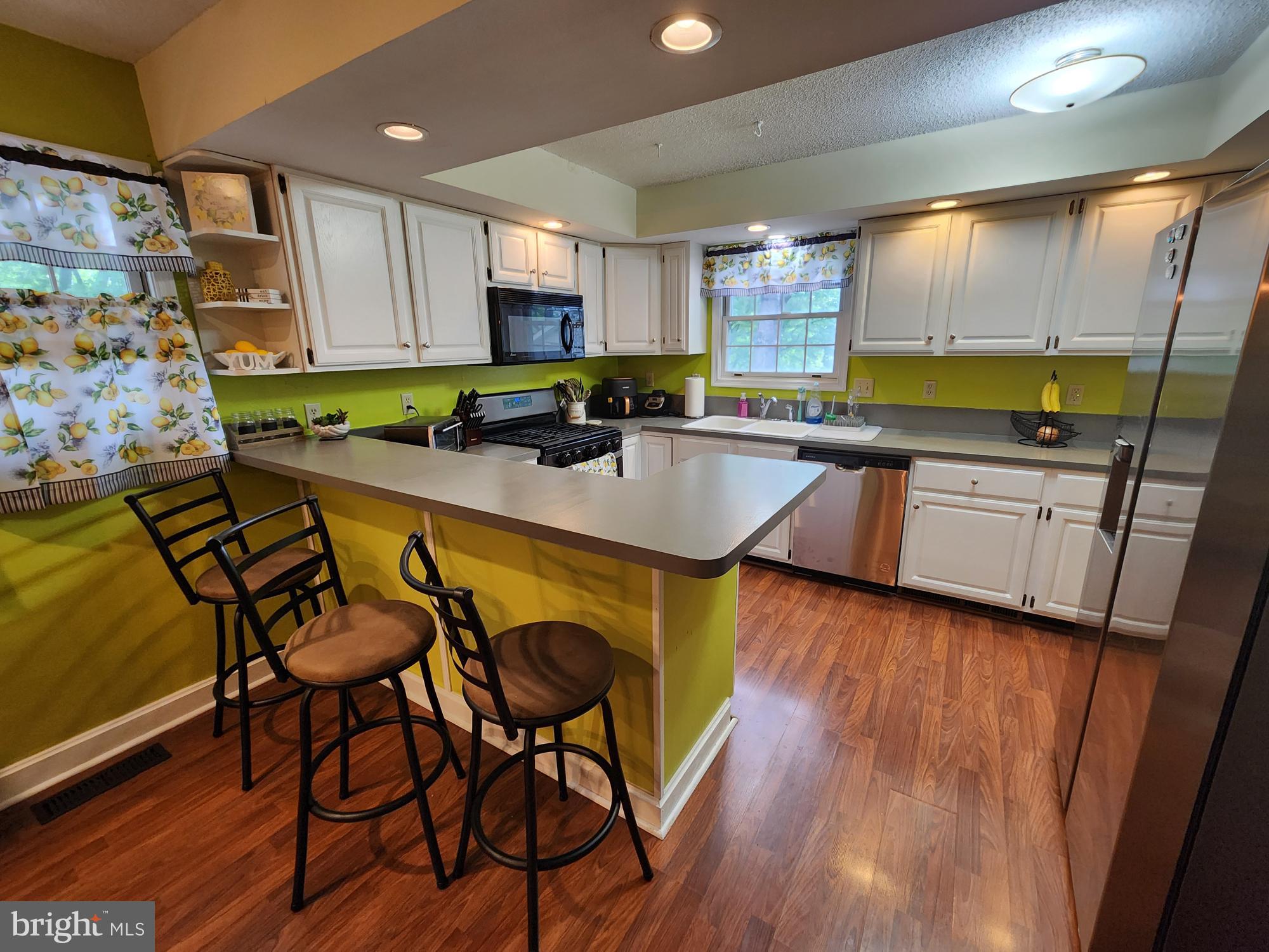 87 Summers Street Inwood, WV 25428 - Photo 9 of 41 a kitchen with stainless steel appliances granite countertop sink microwave and wooden cabinets