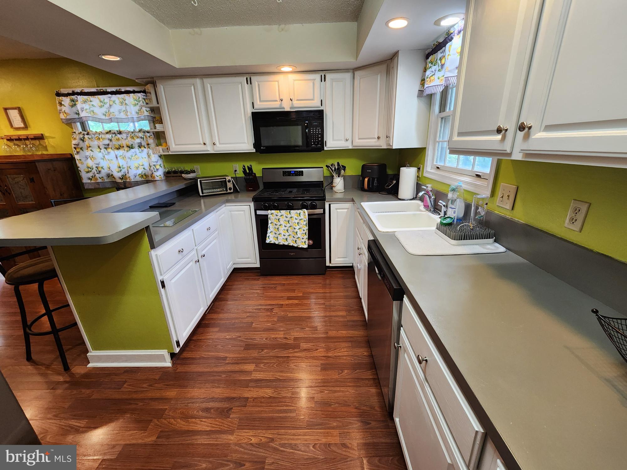 87 Summers Street Inwood, WV 25428 - Photo 10 of 41 a kitchen with stainless steel appliances a sink a stove top oven a sink a counter top space and cabinets