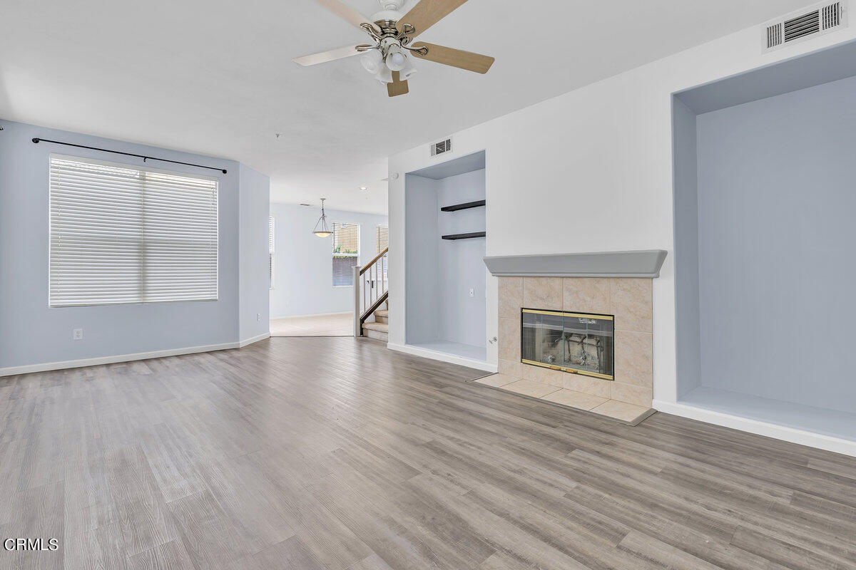 825 Noontide Way Oxnard, CA 93035 - Photo 2 of 26 a view of an empty room with wooden floor fireplace and a window