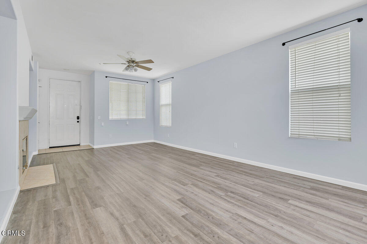825 Noontide Way Oxnard, CA 93035 - Photo 4 of 26 an empty room with wooden floor cabinet and windows