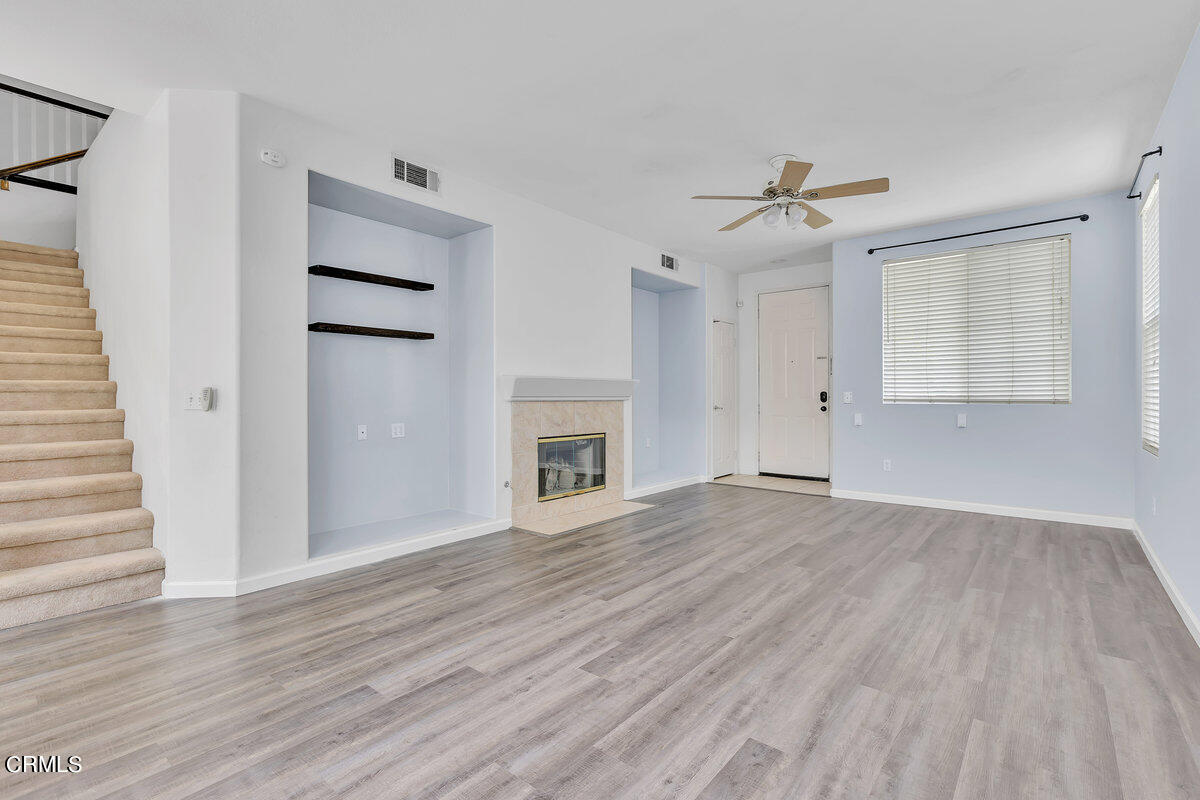 825 Noontide Way Oxnard, CA 93035 - Photo 5 of 26 a view of empty room with wooden floor and fireplace