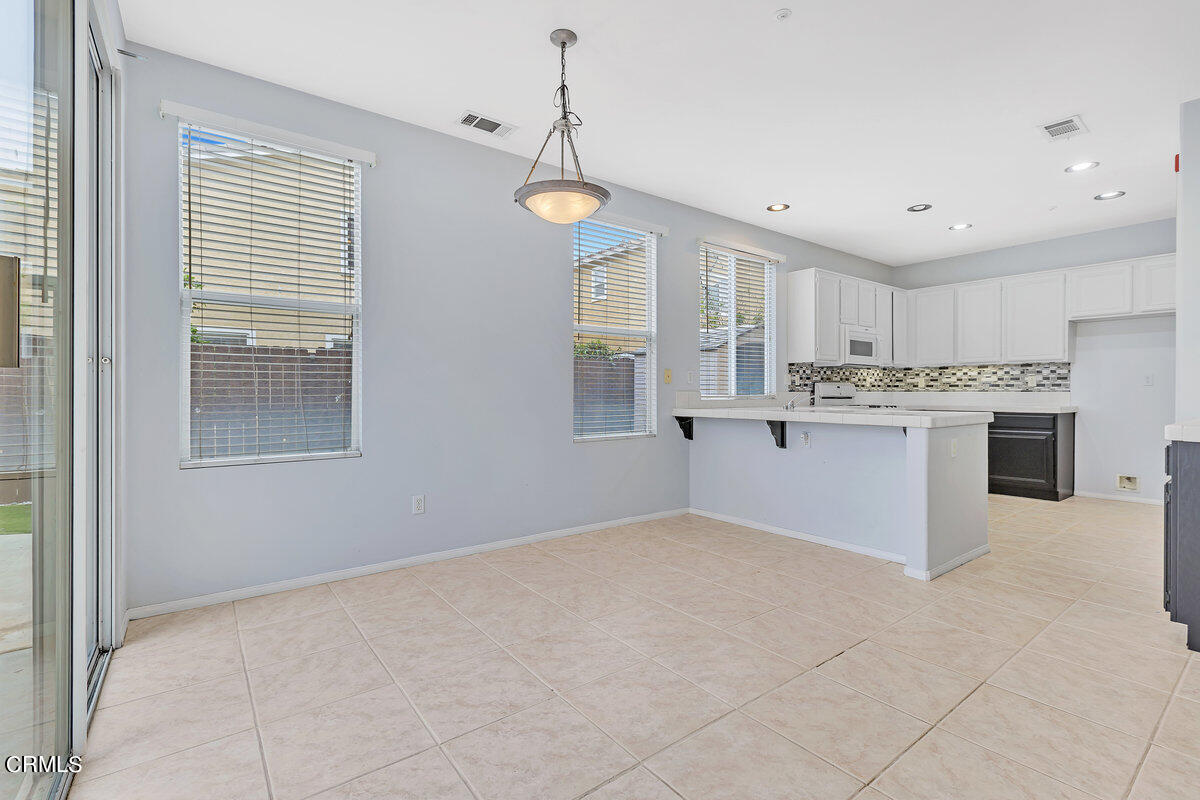 825 Noontide Way Oxnard, CA 93035 - Photo 6 of 26 a kitchen with stainless steel appliances granite countertop a stove oven and a refrigerator with white cabinets