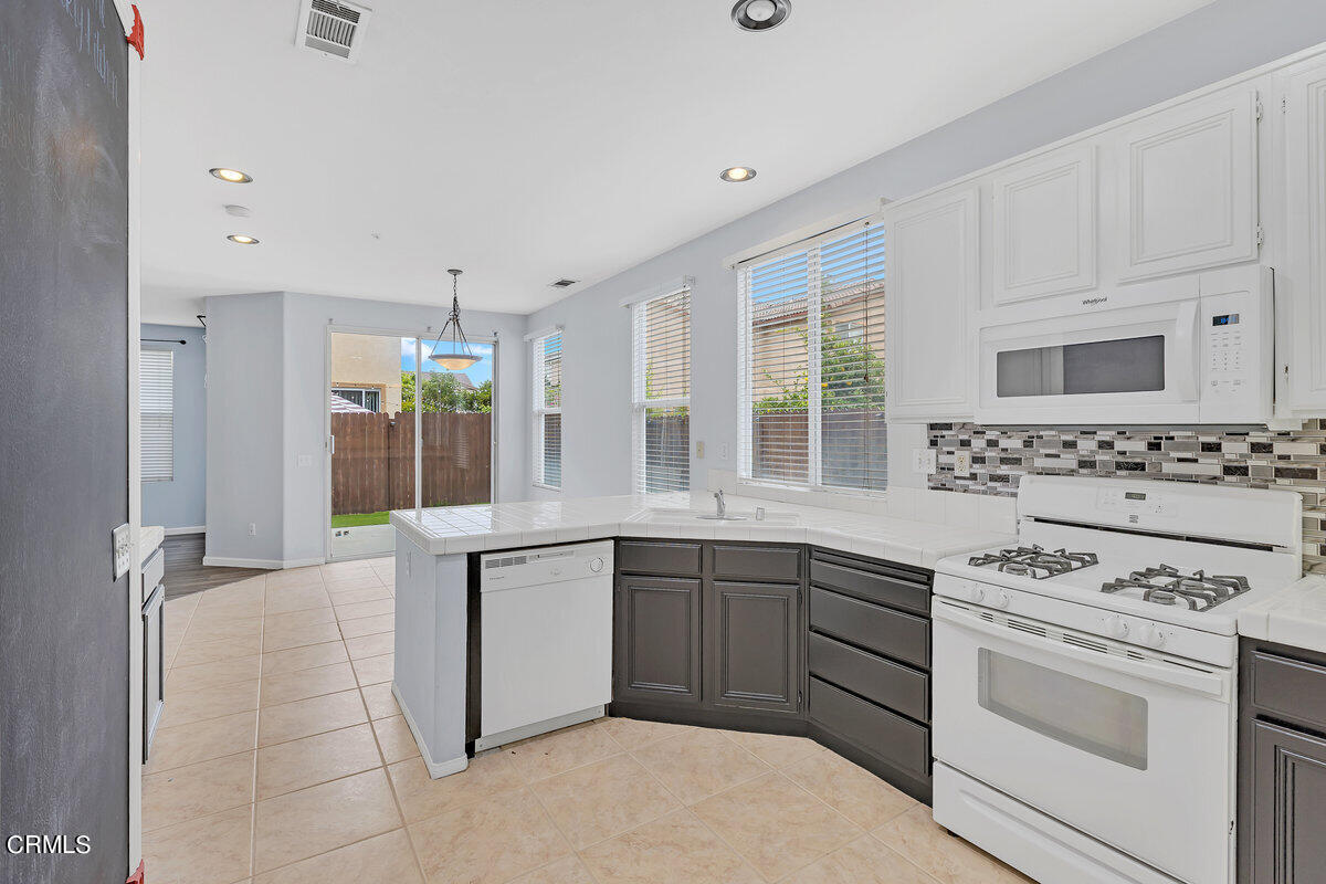 825 Noontide Way Oxnard, CA 93035 - Photo 9 of 26 a kitchen with cabinets appliances a sink and a window