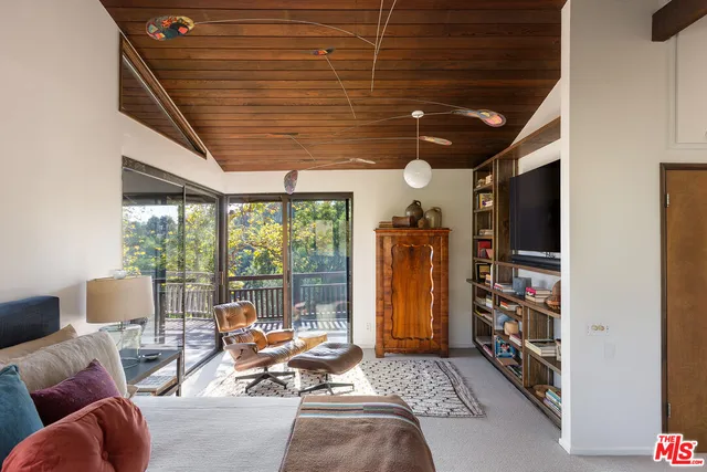 a living room with furniture a flat screen tv and floor to ceiling window