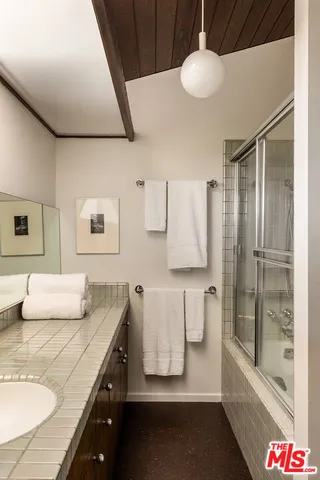 a bathroom with a double vanity sink mirror and bathtub