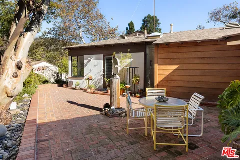 a view of a patio with table and chairs potted plants