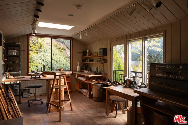 a view of a workspace with furniture and a window