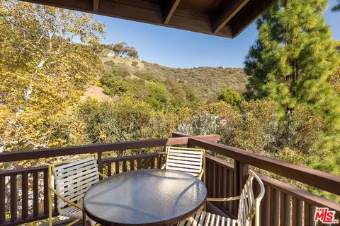 a balcony with table and chairs