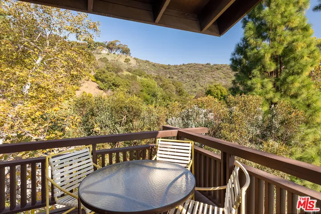 a balcony with table and chairs
