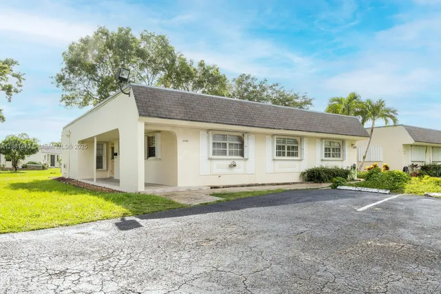 a view of a house with a yard and large tree