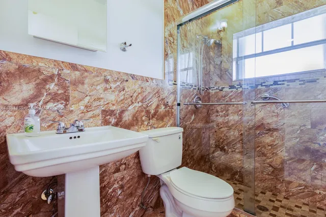 a bathroom with a sink a toilet and mirror