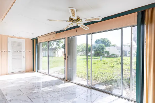 a view of an empty room and window ceiling fan