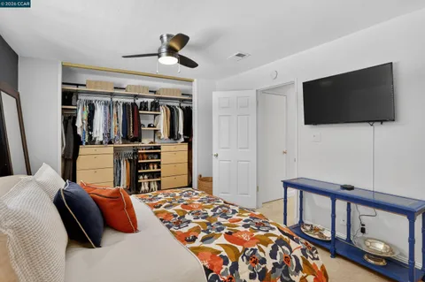 a bedroom with a bed a flat screen tv and dresser