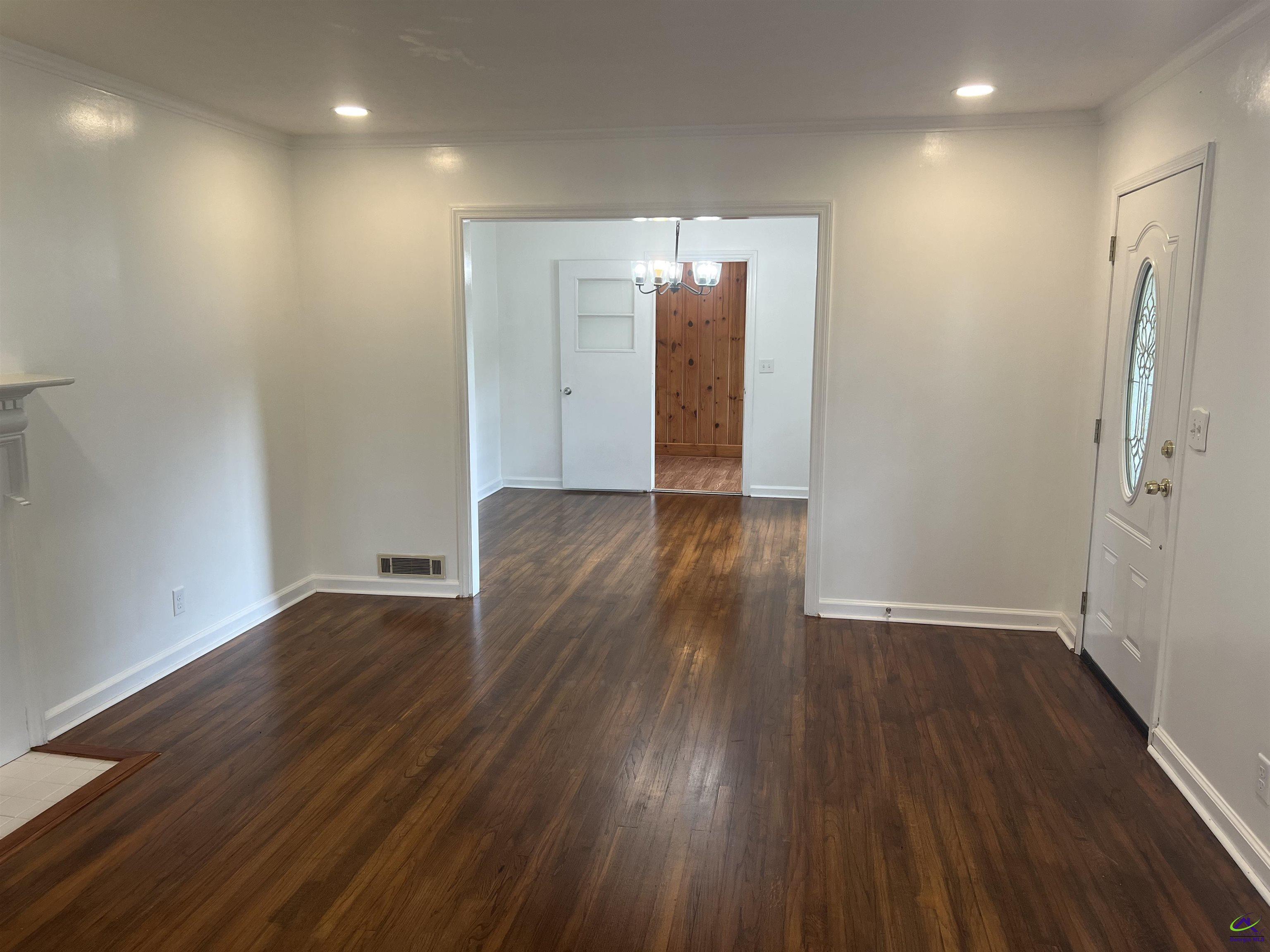 145 South 2nd Street Cochran, GA 31014 - Photo 11 of 24 an empty room with wooden floor and a bathroom