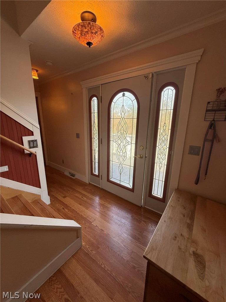 7170 Old Town Road Mount Perry, OH 43760 - Photo 6 of 41 Foyer entrance featuring wood finished floors, ornamental molding, and a textured ceiling