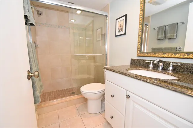 a bathroom with a granite countertop sink toilet and shower