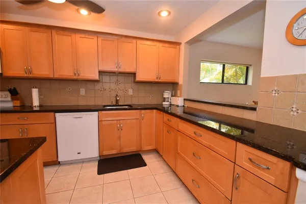 a kitchen with granite countertop a sink a stove and cabinets