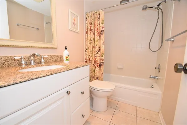 a bathroom with a granite countertop sink a toilet and shower