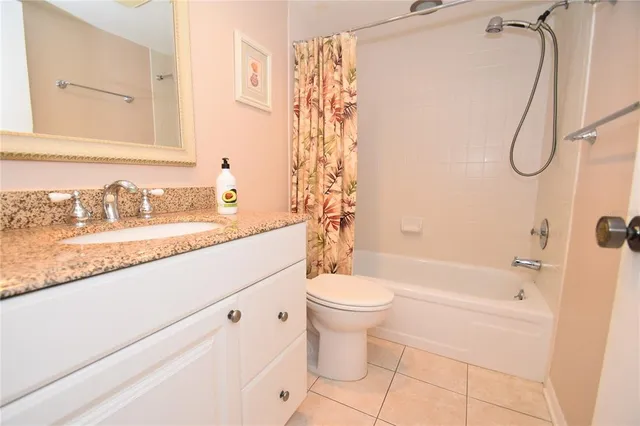 a bathroom with a granite countertop sink a toilet and shower
