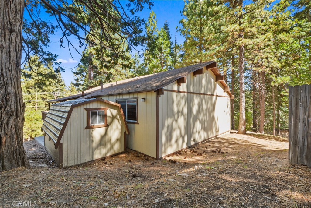 1942 Wilderness Road Running Springs, CA 92382 - Photo 6 of 20 a view of a small house with a tree and wooden fence