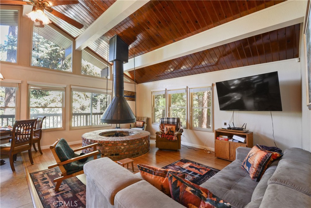 1942 Wilderness Road Running Springs, CA 92382 - Photo 10 of 20 a living room with furniture a flat screen tv and a floor to ceiling window