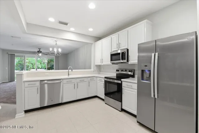 a large kitchen with cabinets stainless steel appliances and a counter space