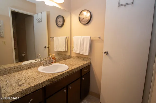 a bathroom with a granite countertop sink and a mirror