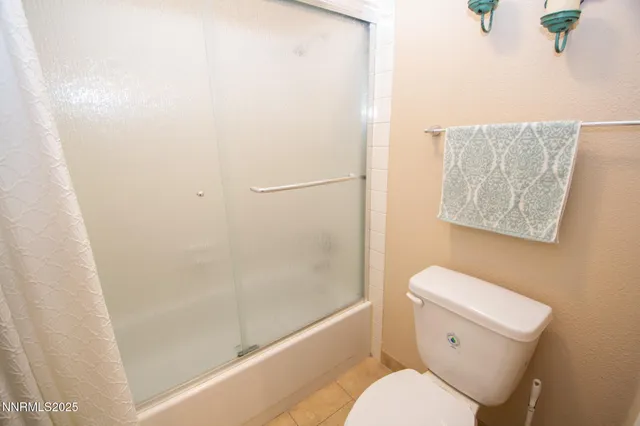 a white toilet sitting next to a bath tub