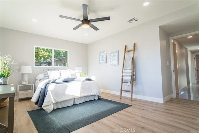 a spacious bedroom with a bed and a ceiling fan