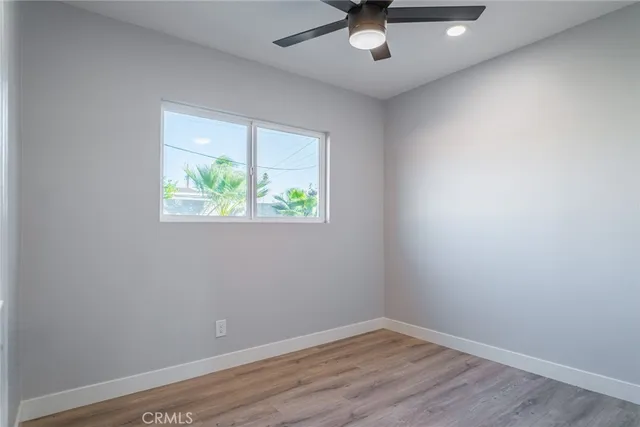 an empty room with a window and a ceiling fan