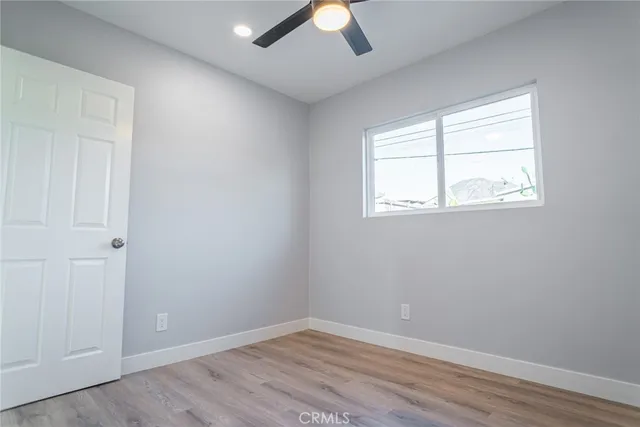 an empty room with a window and wooden floor