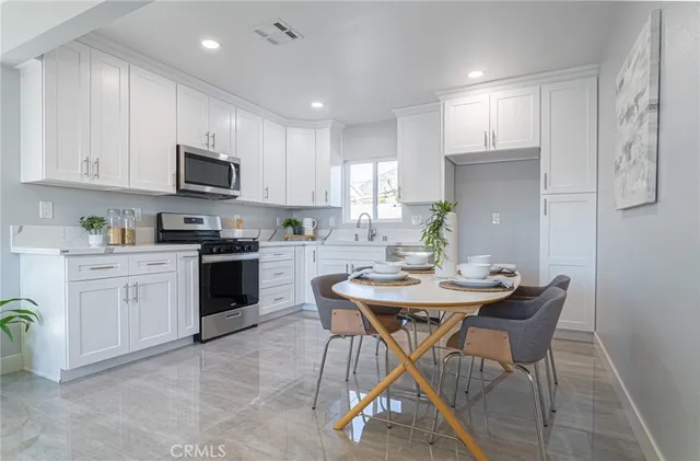 a kitchen with white cabinets a sink and appliances